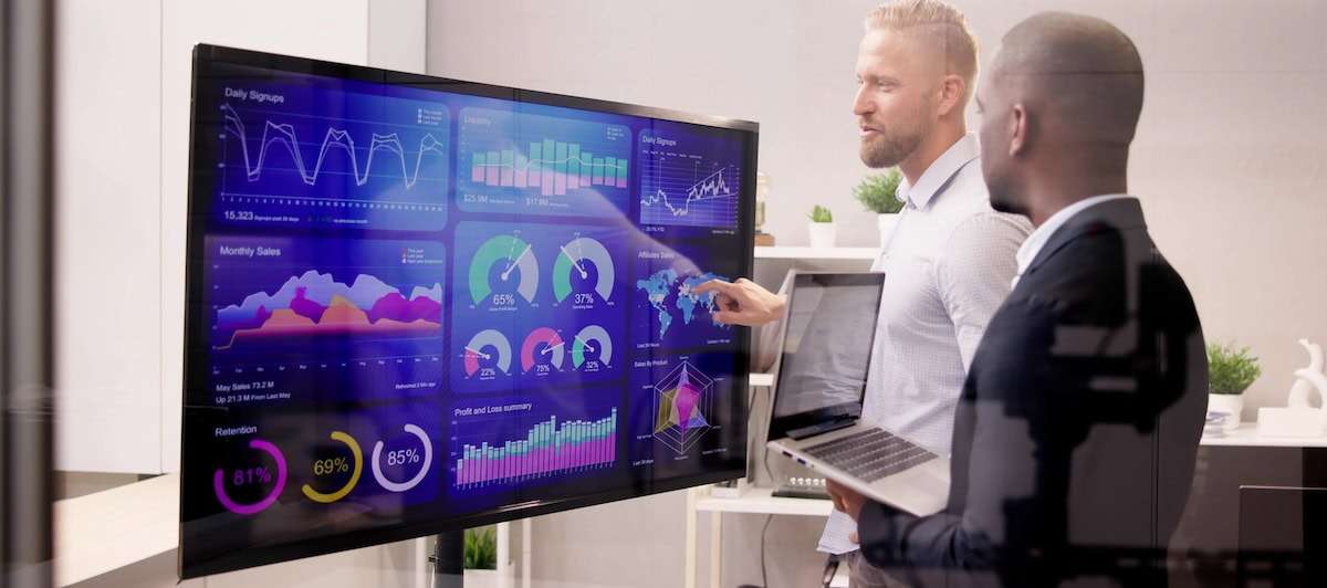 a man pointing at a large screen